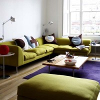 Zielona sofa + fioletowy dywan zgrabna całość.