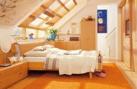 sypialnia na poddaszu pomarańcz i jasne drewno